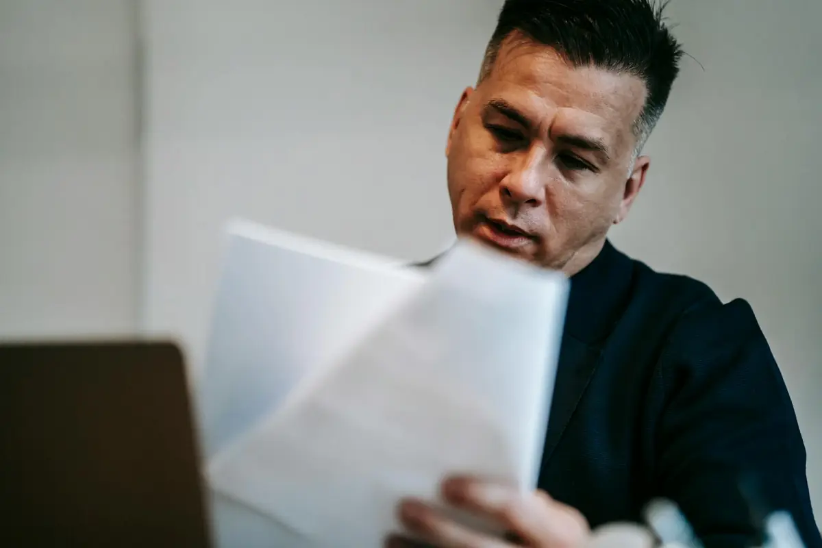Persona revisando con atención un documento de notificación de cesión de su crédito en casa